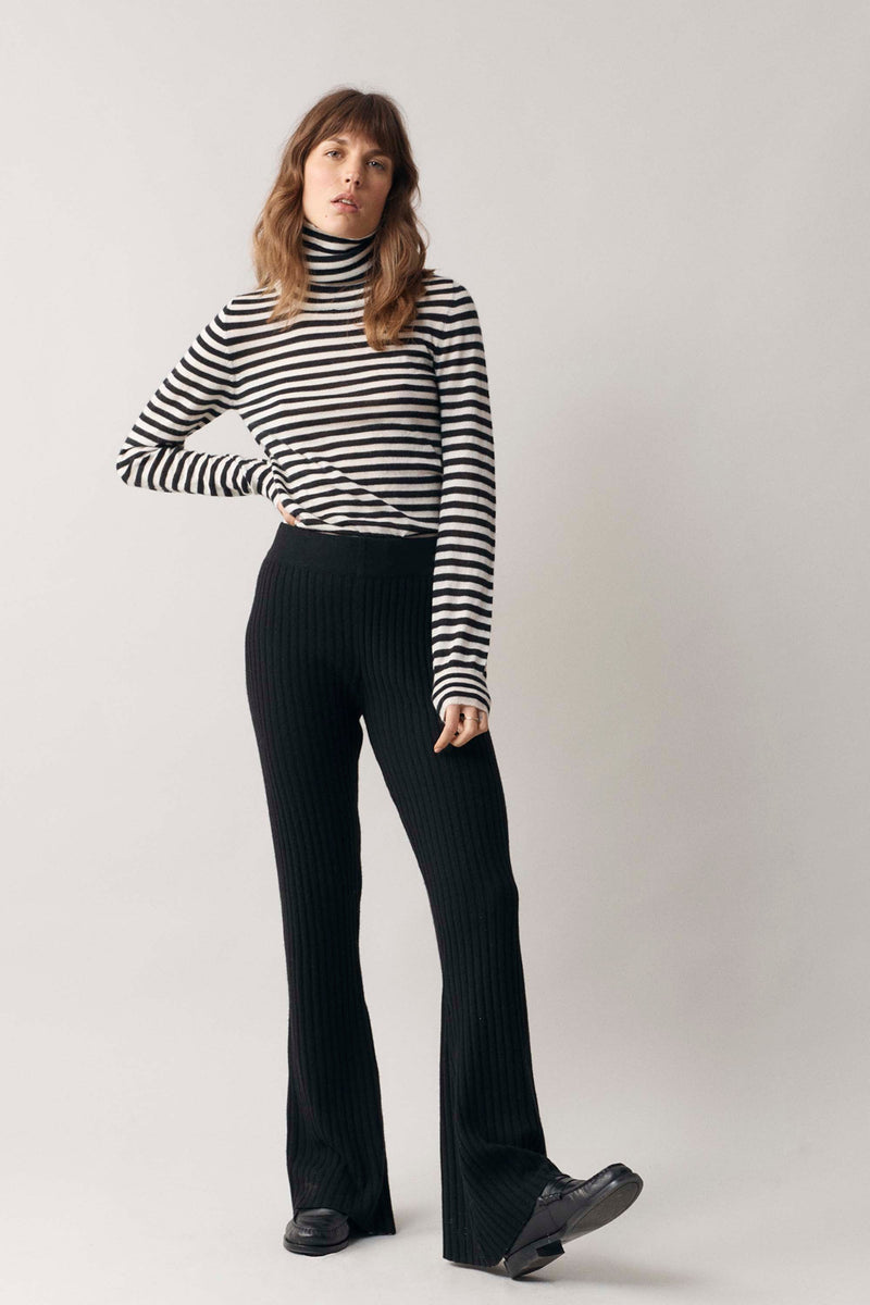 Full-body perspective of woman modelling our black and white stripe cashmere roll neck